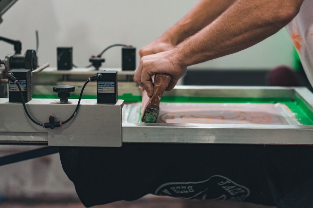 Pessoa trabalhando em equipamento de impressão em oficina de personalização