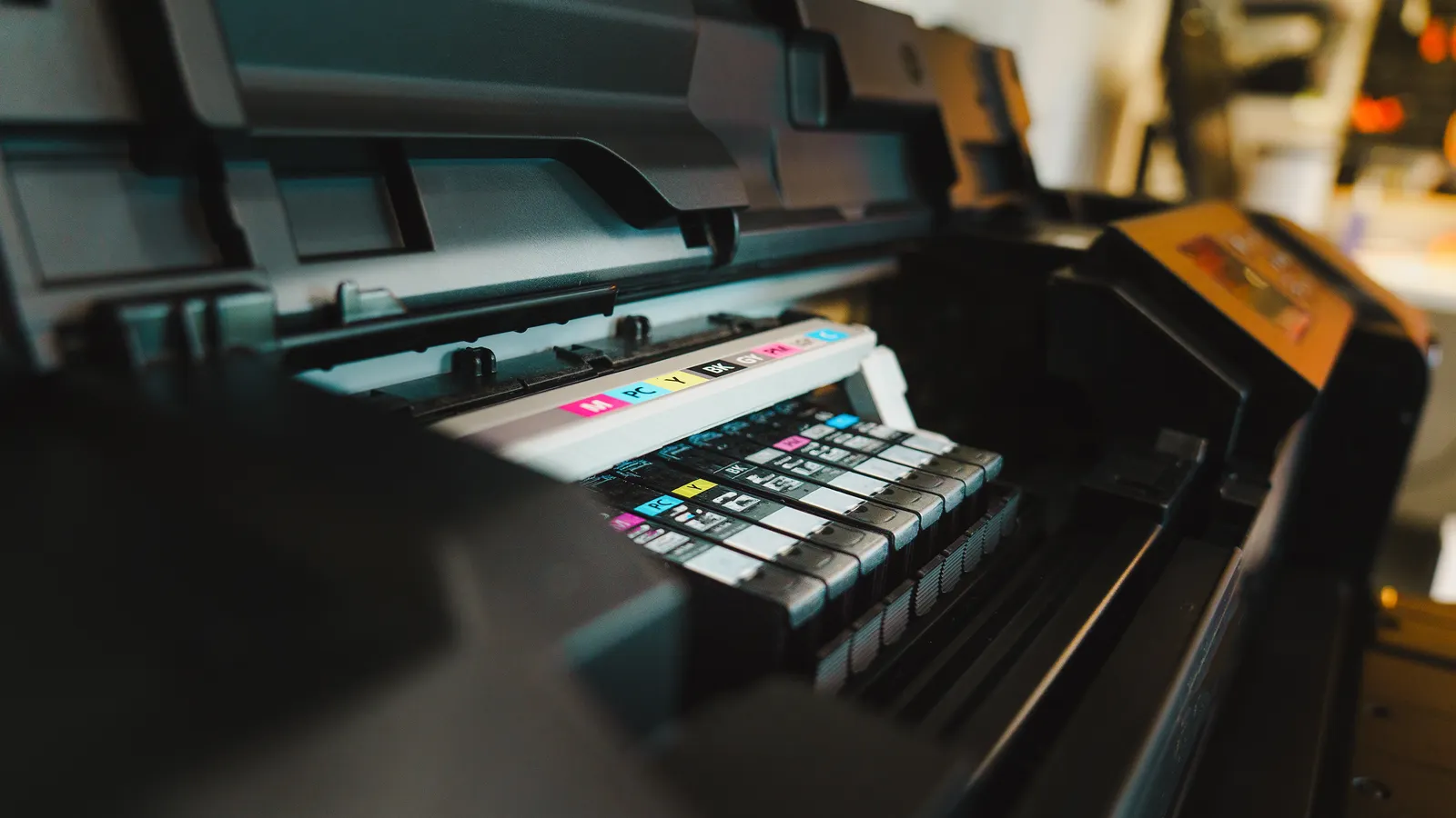 Detalhe de impressora jato de tinta com sistema de cores para ilustrar a escolha de equipamento de sublimação