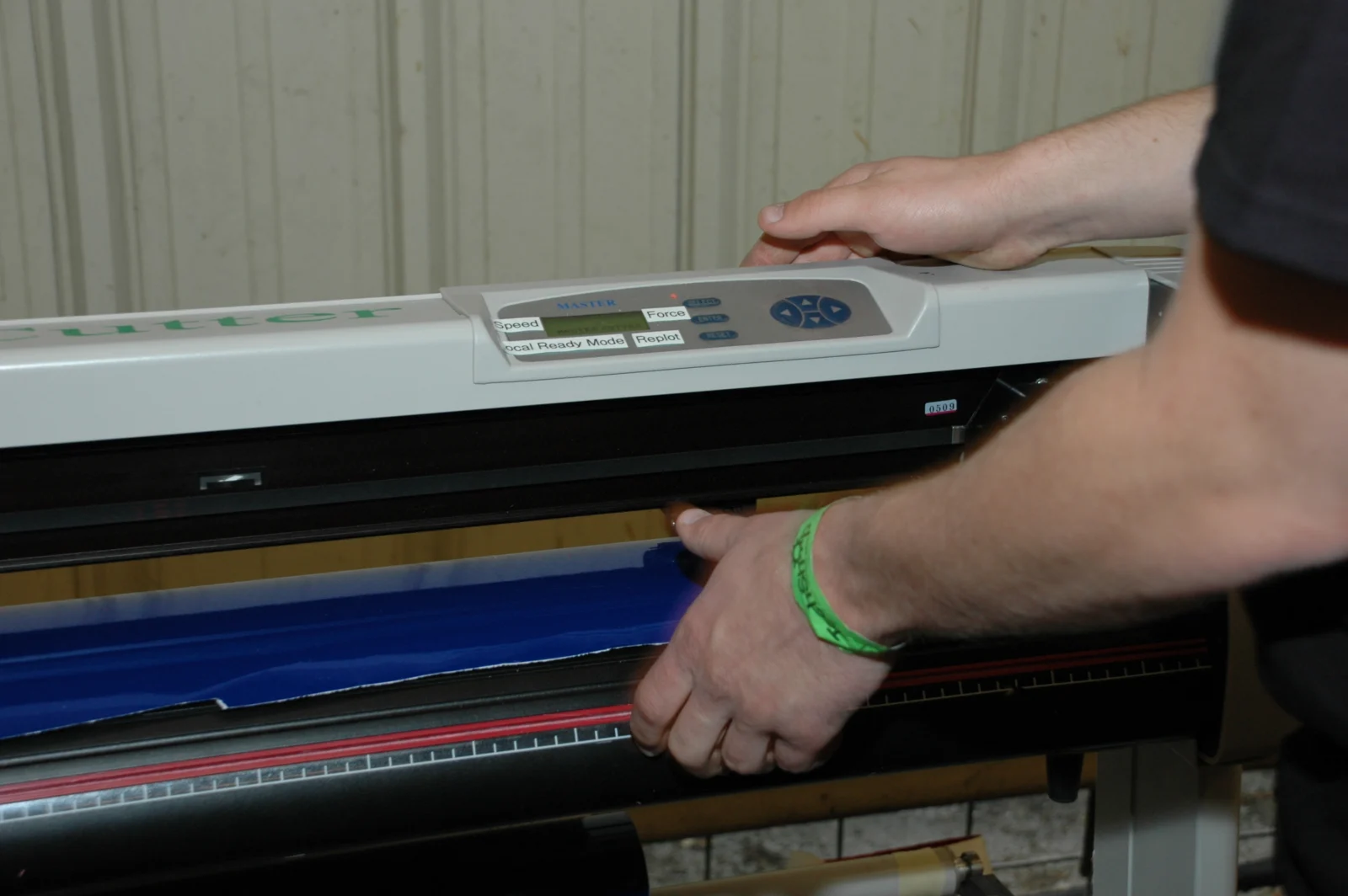 Vinil adesivo sendo preparado em uma plotter de recorte